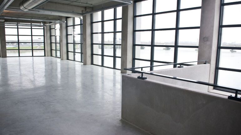 Luftig rom med betonggulv og tore vinduer